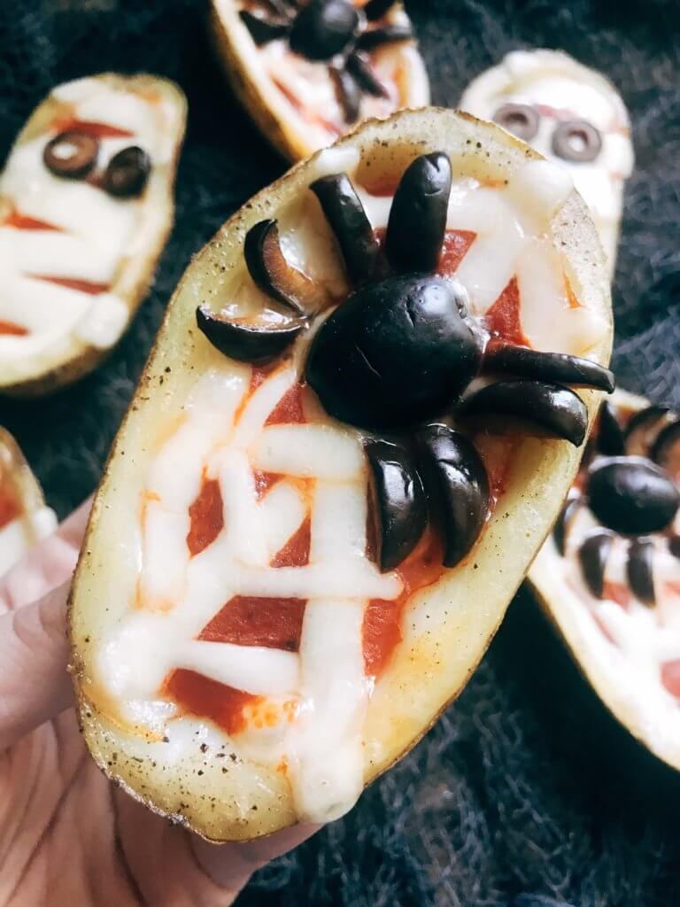 Fun, savory Halloween recipe perfect for fall parties and lunch or dinner. Potato skins are filled with pizza toppings of pizza sauce and provolone cheese, then decorated as a mummy, ghost, or spider web using additional cheese and black olives. A festive appetizer for adult and kid party food celebrating All Hallows' Eve. Vegetarian and gluten free. Halloween Pizza Potato Skins | Three Olives Branch | www.threeolivesbranch.com