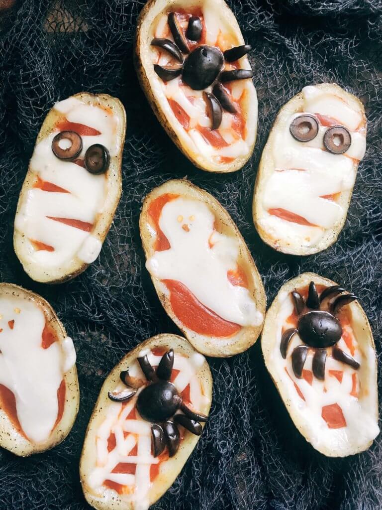 Fun, savory Halloween recipe perfect for fall parties and lunch or dinner. Potato skins are filled with pizza toppings of pizza sauce and provolone cheese, then decorated as a mummy, ghost, or spider web using additional cheese and black olives. A festive appetizer for adult and kid party food celebrating All Hallows' Eve. Vegetarian and gluten free. Halloween Pizza Potato Skins | Three Olives Branch | www.threeolivesbranch.com