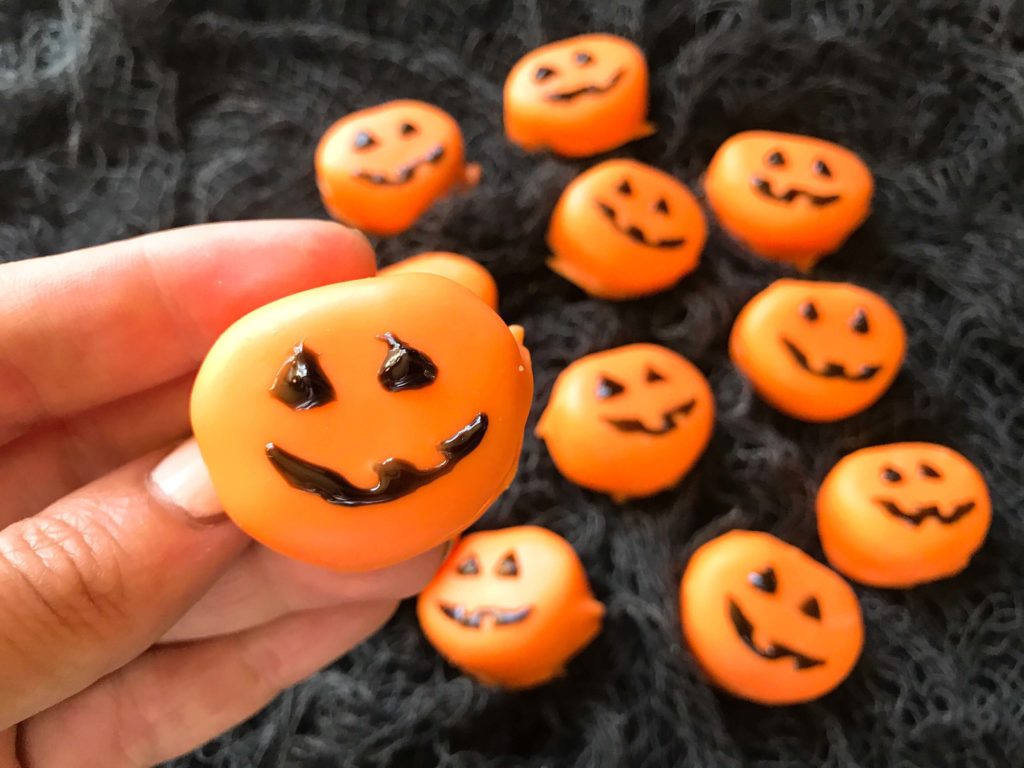 Candy pumpkin marshmallows, perfect for Halloween! Marshmallows are coated in melted orange candy with black piping gel for their jack-o-lantern faces. A fun dessert treat to make for Halloween parties. Halloween Candy Dipped Jack-O-Lantern Pumpkin Marshmallows | Three Olives Branch | www.threeolivesbranch.com #halloween #marshmallow #pumpkin #jackolantern