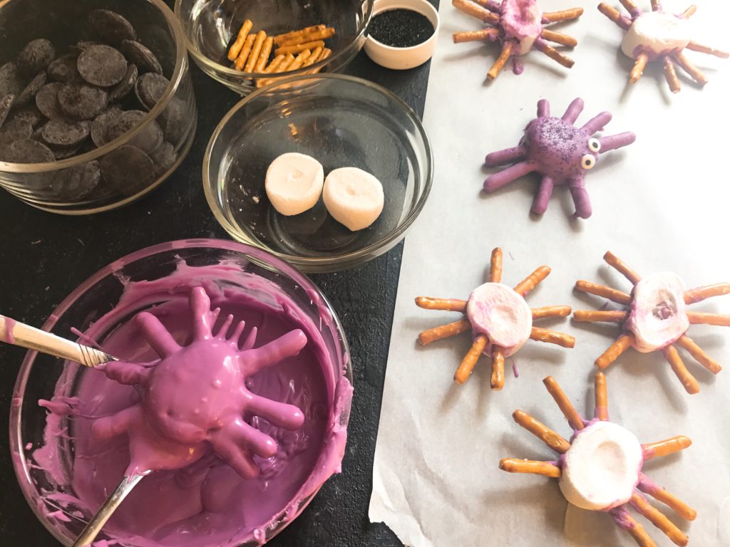 Candy spider marshmallows, perfect for Halloween! Marshmallows are coated in melted purple or black candy with pretzels for legs. Decorated with candy eyes and colored sugar sprinkles. A fun dessert treat to make for Halloween parties. Halloween Candy Dipped Spider Marshmallows | Three Olives Branch | www.threeolivesbranch.com #halloween #marshmallow #spider