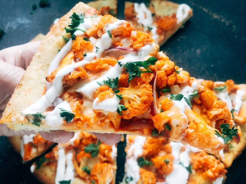 A vegetarian pizza recipe using the flavors of buffalo wings for inspiration. Roasted cauliflower is tossed with buffalo wing sauce on a ranch pizza crust. Great for game day and the Super Bowl to get a vegetarian buffalo recipe! Vegetarian Buffalo Cauliflower Pizza | Three Olives Branch | www.threeolivesbranch.com #superbowl #gameday #vegetarian #buffalowing