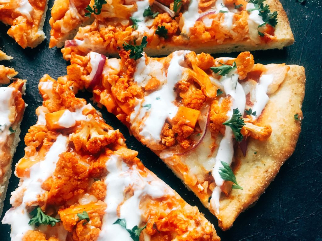 A vegetarian pizza recipe using the flavors of buffalo wings for inspiration. Roasted cauliflower is tossed with buffalo wing sauce on a ranch pizza crust. Great for game day and the Super Bowl to get a vegetarian buffalo recipe! Vegetarian Buffalo Cauliflower Pizza | Three Olives Branch | www.threeolivesbranch.com #superbowl #gameday #vegetarian #buffalowing