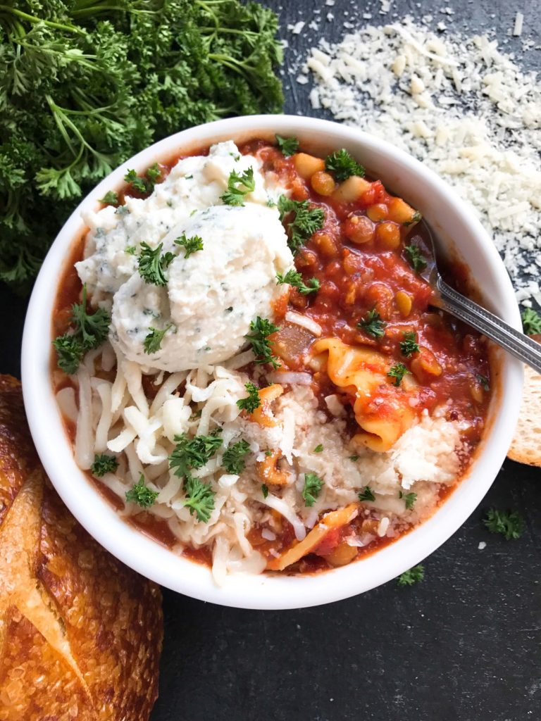 A hearty soup perfect for your crock pot on busy and cold nights. Simple and easy to prepare, this soup is topped with herbed ricotta cheese for classic Italian comfort food in a bowl. Slow Cooker Vegetarian Lentil Lasagna Soup | Three Olives Branch | www.threeolivesbranch.com #italianfood #slowcookersoup #lasagna #vegetarianrecipe