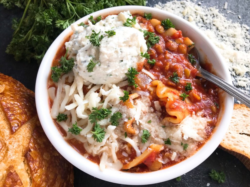 A hearty soup perfect for your crock pot on busy and cold nights. Simple and easy to prepare, this soup is topped with herbed ricotta cheese for classic Italian comfort food in a bowl. Slow Cooker Vegetarian Lentil Lasagna Soup | Three Olives Branch | www.threeolivesbranch.com #italianfood #slowcookersoup #lasagna #vegetarianrecipe