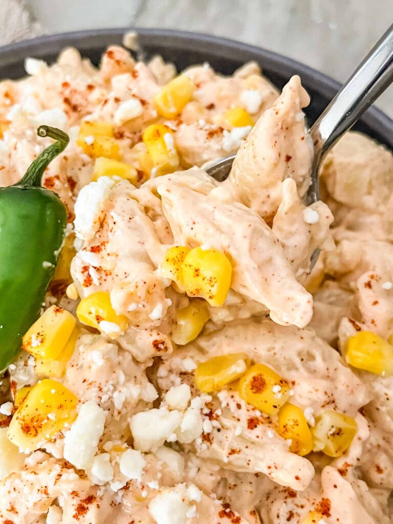 Close up of a spoon digging into a bowl of Mexican Street Corn Pasta Salad