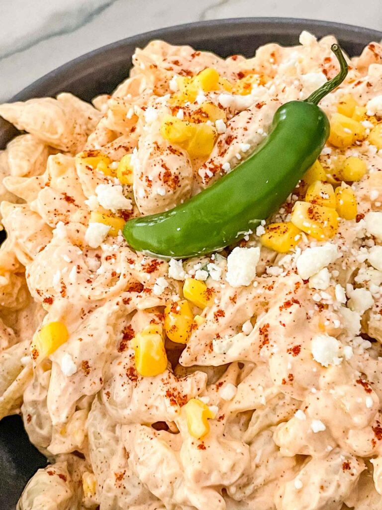 Close up of Mexican Street Corn Pasta Salad with a pepper on top