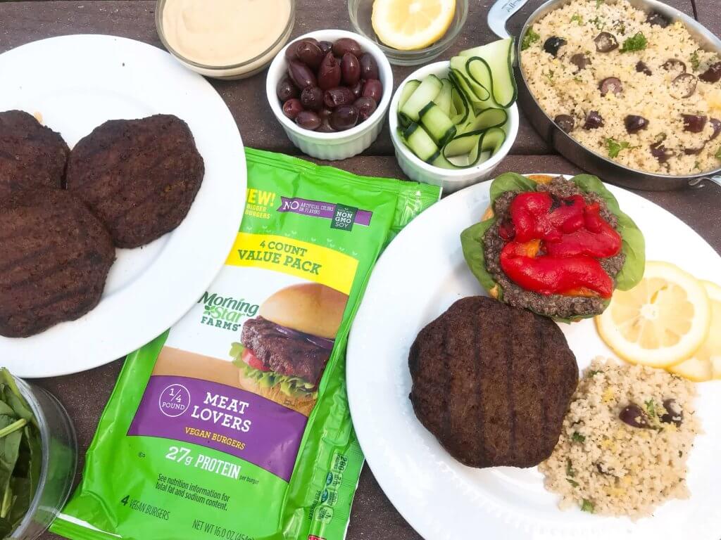 Vegan burgers topped with cucumber, olive tapenade, roasted red peppers, hummus, and spinach. Made with MorningStar Farms® Meat Lovers Burgers, these burgers are ready in just 20 minutes. Vegan Mediterranean Burgers #grilling #MorningStarFarms #MakeRoomOnYourGrill #ad