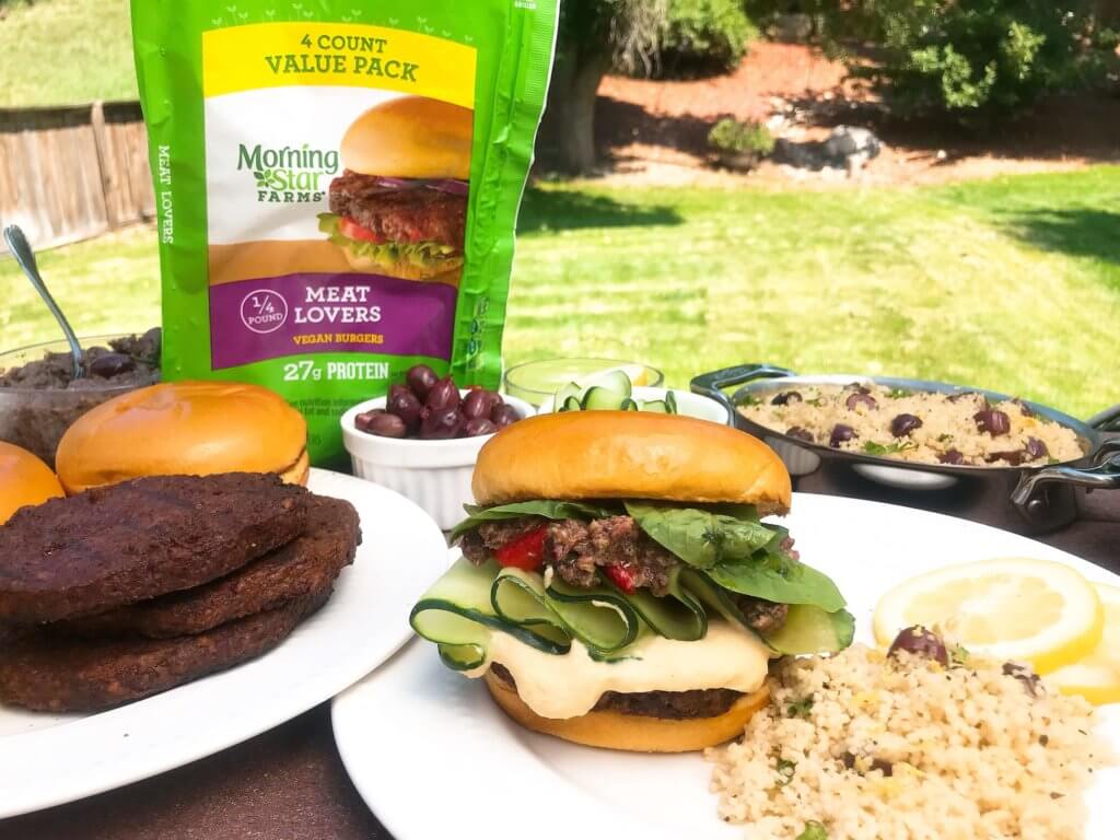 Vegan burgers topped with cucumber, olive tapenade, roasted red peppers, hummus, and spinach. Made with MorningStar Farms® Meat Lovers Burgers, these burgers are ready in just 20 minutes. Vegan Mediterranean Burgers #grilling #MorningStarFarms #MakeRoomOnYourGrill #ad