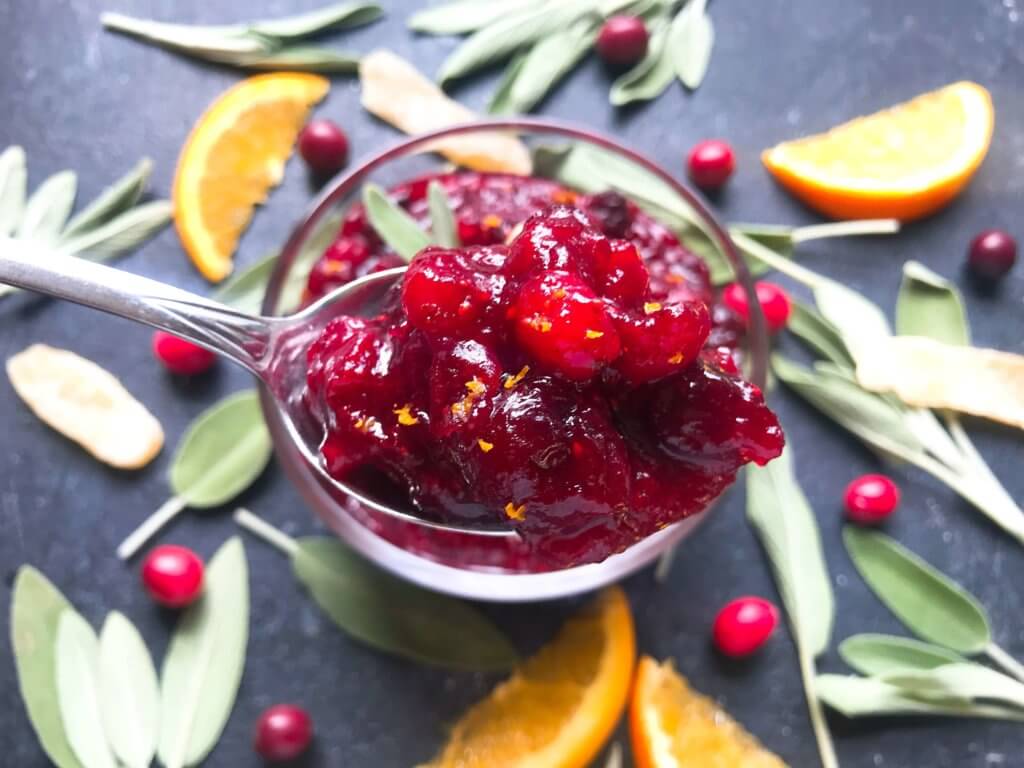 A quick and simple cranberry sauce recipe ready in 10 minutes. Flavored with ginger and orange, this sauce is vegetarian, vegan, and gluten free (GF). Perfect for Thanksgiving, Christmas, Easter, and holiday side dish. Make ahead! Ginger Orange Cranberry Sauce | Three Olives Branch | www.threeolivesbranch.com #thanksgiving #cranberrysauce #christmas