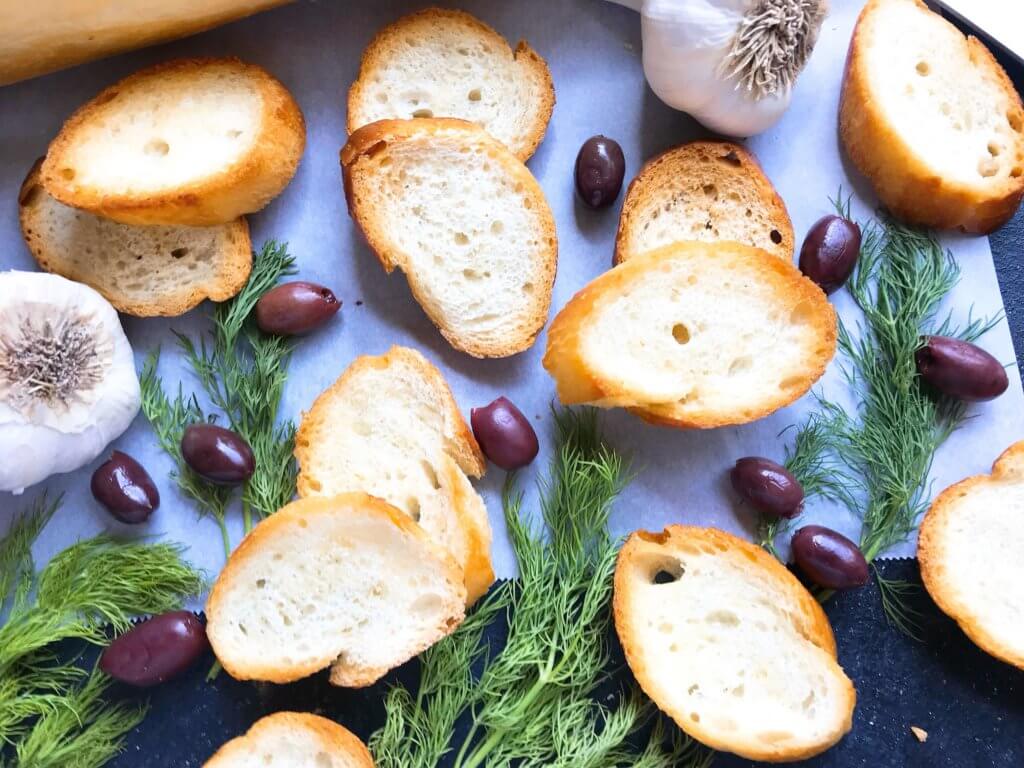 10 minutes to make toasted bread crostini! A perfect appetizer for game day, parties, and holiday entertaining. Top with your favorite spread or dip. Vegan and vegetarian recipe. How To Make Crostini | Three Olives Branch | www.threeolivesbranch.com #holidayappetizer #veganrecipe 