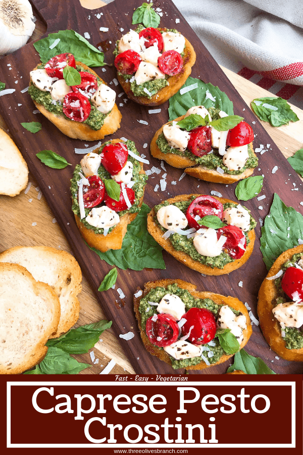 Pin image for Caprese Pesto Crostini on wood board with title at bottom