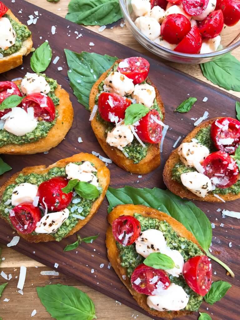 Caprese Pesto Crostini on a wood board