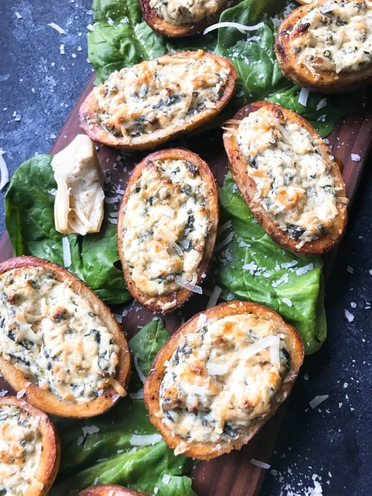 Classic spinach artichoke dip stuffed in potato skin shells. Great recipe for game day, holiday entertaining, and party appetizer. Vegetarian and gluten free. Spinach Artichoke Dip Potato Skins #appetizer #spinachartichokedip