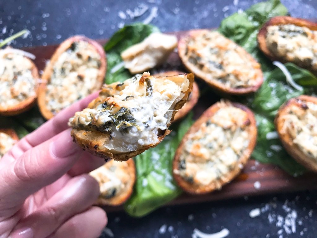 Classic spinach artichoke dip stuffed in potato skin shells. Great recipe for game day, holiday entertaining, and party appetizer. Vegetarian and gluten free. Spinach Artichoke Dip Potato Skins #appetizer #spinachartichokedip