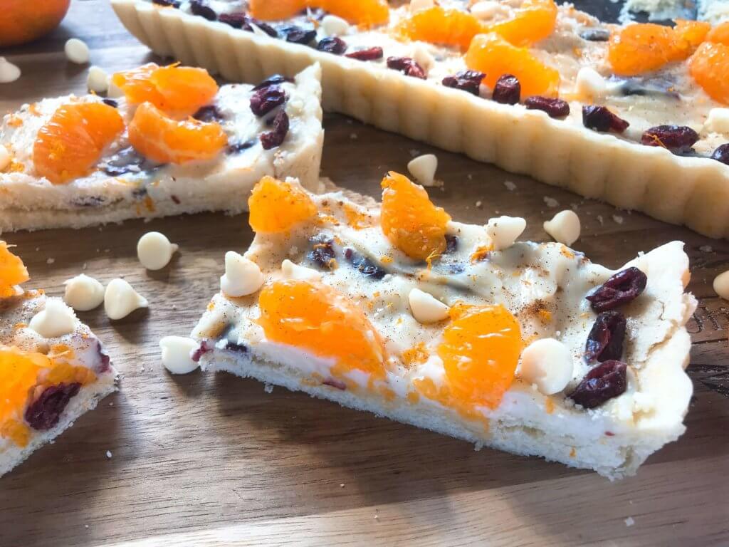 A fast and easy dessert recipe ready in just 30 minutes. Cranberry Orange Tart has a soft cookie shell with a cream cheese filling mixed with dried cranberries, orange zest, and white chocolate chips. #christmasdessert #holidayrecipes #holidaybaking #fruittart