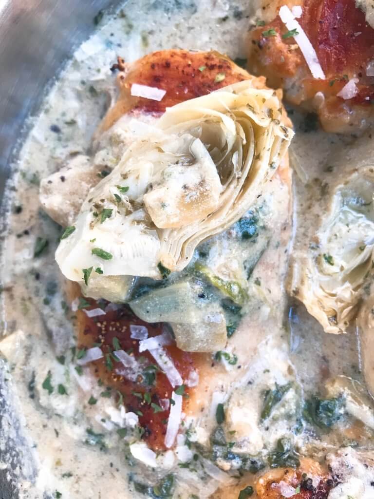 One pot Creamy Skillet Spinach Artichoke Chicken ready in 30 minutes for a fast and easy dinner recipe. Chicken is browned and served in a creamy Parmesan cheese sauce with spinach and artichoke hearts. Gluten free. #chickenrecipes #glutenfreerecipes #chickendinner