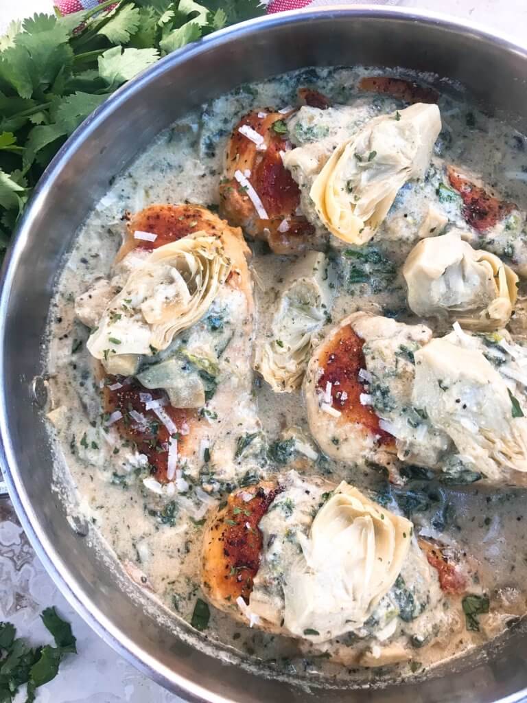 One pot Creamy Skillet Spinach Artichoke Chicken ready in 30 minutes for a fast and easy dinner recipe. Chicken is browned and served in a creamy Parmesan cheese sauce with spinach and artichoke hearts. Gluten free. #chickenrecipes #glutenfreerecipes #chickendinner