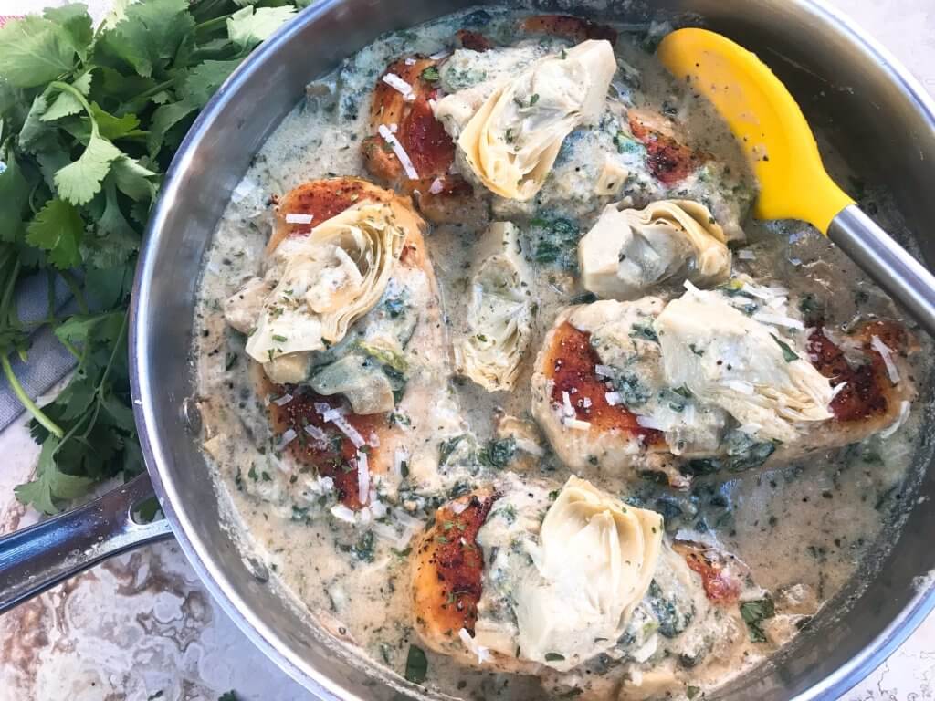 One pot Creamy Skillet Spinach Artichoke Chicken ready in 30 minutes for a fast and easy dinner recipe. Chicken is browned and served in a creamy Parmesan cheese sauce with spinach and artichoke hearts. Gluten free. #chickenrecipes #glutenfreerecipes #chickendinner