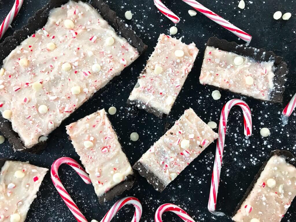 A simple Christmas baking recipe ready in 30 minutes. Chocolate Peppermint Tart is a soft cocoa shell filled with a peppermint cream cheese filling and topped with crushed candy canes and white chocolate. Fast and easy vegetarian holiday recipe. #chocolatepeppermint #christmasdessert #peppermintrecipes