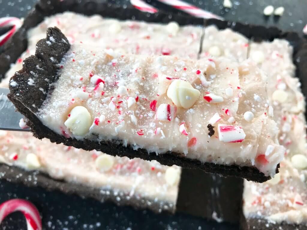 A simple Christmas baking recipe ready in 30 minutes. Chocolate Peppermint Tart is a soft cocoa shell filled with a peppermint cream cheese filling and topped with crushed candy canes and white chocolate. Fast and easy vegetarian holiday recipe. #chocolatepeppermint #christmasdessert #peppermintrecipes