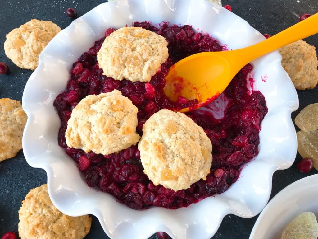 Holiday Cranberry Ginger Cobbler is a perfect quick and simple Christmas or Thanksgiving dessert ready in 30-45 minutes. A cranberry ginger filling is topped with light ginger cinnamon biscuits. A perfect holiday dessert. #christmasdessert #thanksgivingdessert #holidaydessert #cranberryrecipes