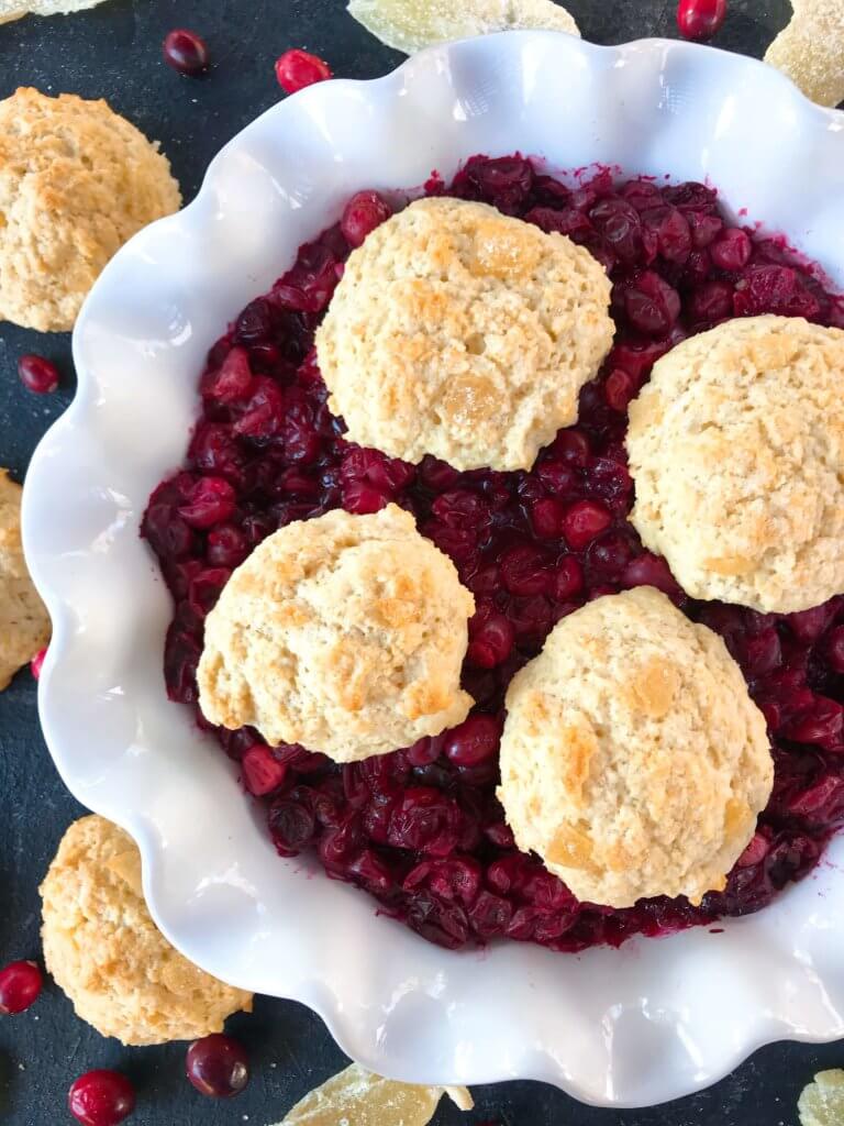 Holiday Cranberry Ginger Cobbler is a perfect quick and simple Christmas or Thanksgiving dessert ready in 30-45 minutes. A cranberry ginger filling is topped with light ginger cinnamon biscuits. A perfect holiday dessert. #christmasdessert #thanksgivingdessert #holidaydessert #cranberryrecipes