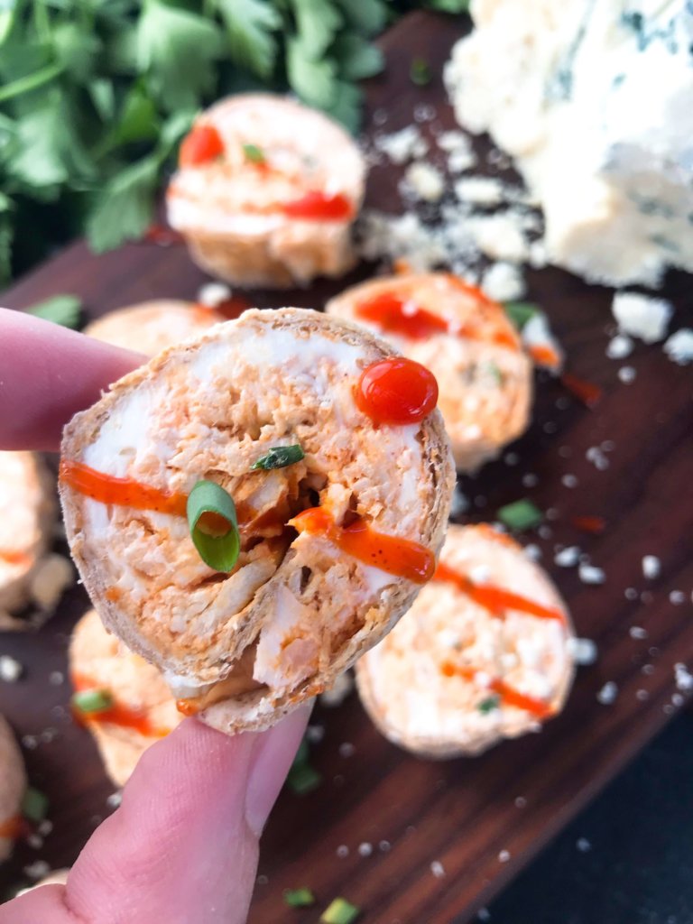 Classic buffalo chicken wing flavors in a finger food appetizer. Buffalo Chicken Pinwheel Roll Ups filled with cream cheese, blue cheese, shredded chicken, and buffalo wing sauce rolled up in a tortilla. Simple, fast, and easy game day tailgating recipe. #gamedayrecipes #buffalowing #buffalochicken