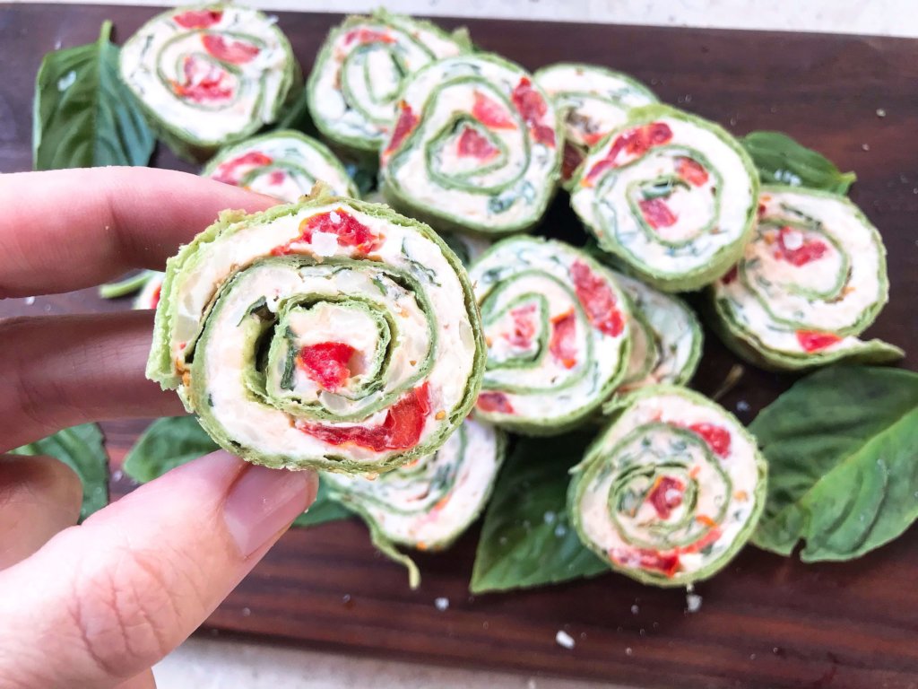 Fast and simple appetizer recipe. Caprese Pinwheel Roll Ups are filled with cream cheese, tomatoes, fresh basil, mozzarella, and Parmesan rolled up in tortillas and sliced into party finger food bites. Vegetarian. #caprese #appetizerrecipes #vegetarianrecipes