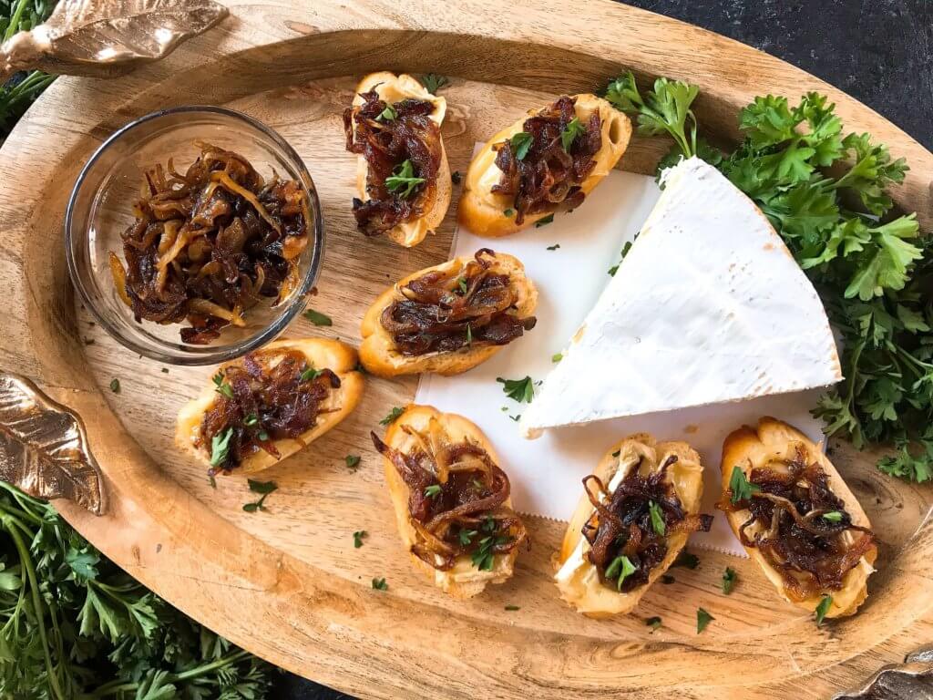 Caramelized Onion and Brie Crostini recipe. Fast and easy appetizer recipe. Vegetarian finger food for holiday entertaining. Brie cheese and onion on a toasted bread slice. #appetizerrecipes #vegetarianrecipes 