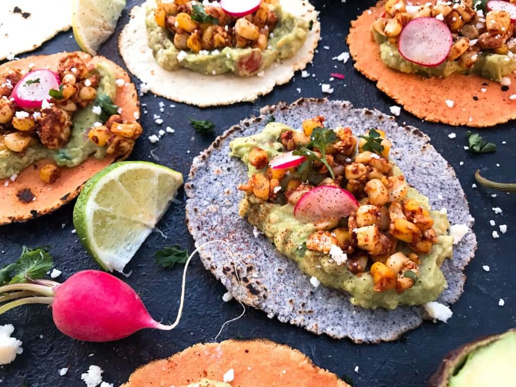 Ready in 15 minutes, these Mexican Street Corn Guacamole Tacos are a fast and simple dinner recipe. Fresh guacamole and corn salsa are layered for a healthy Mexican recipe and quick dinner. Vegetarian and gluten free. Vegan friendly. #healthyrecipes #healthyvegetarian #tacorecipes #vegetarianrecipes #glutenfreerecipes