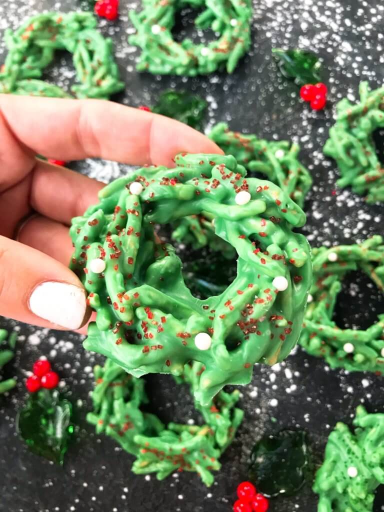 A hand holding a wreath cookie