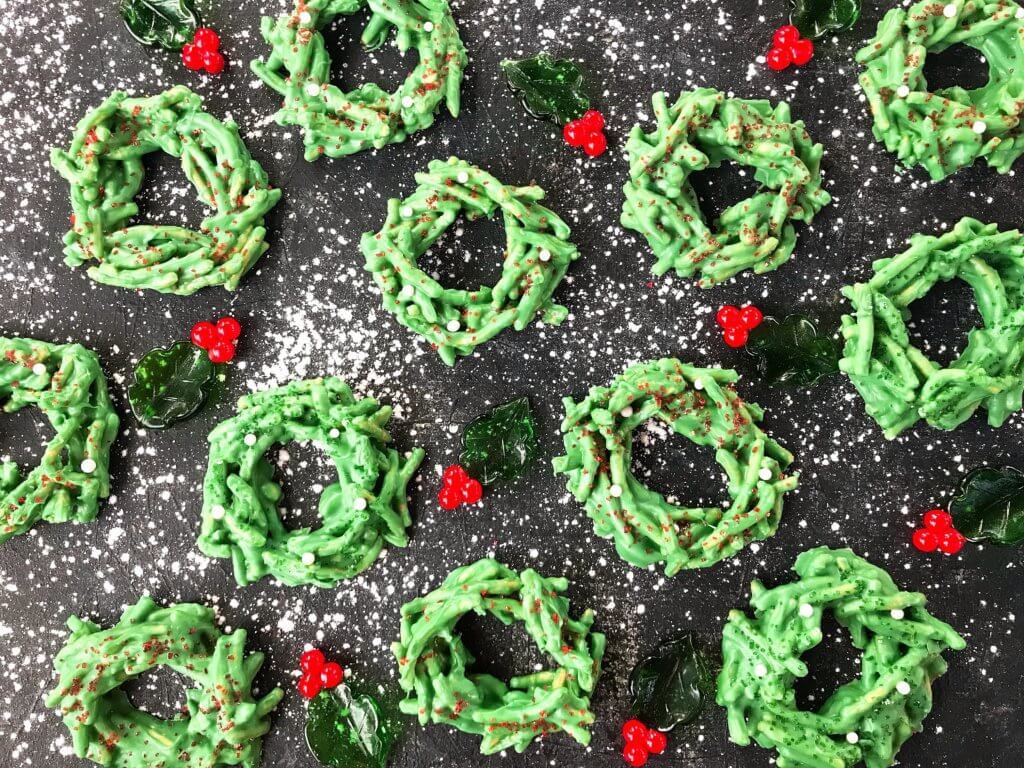 No Bake Christmas Wreath Cookies on a black background all spread out