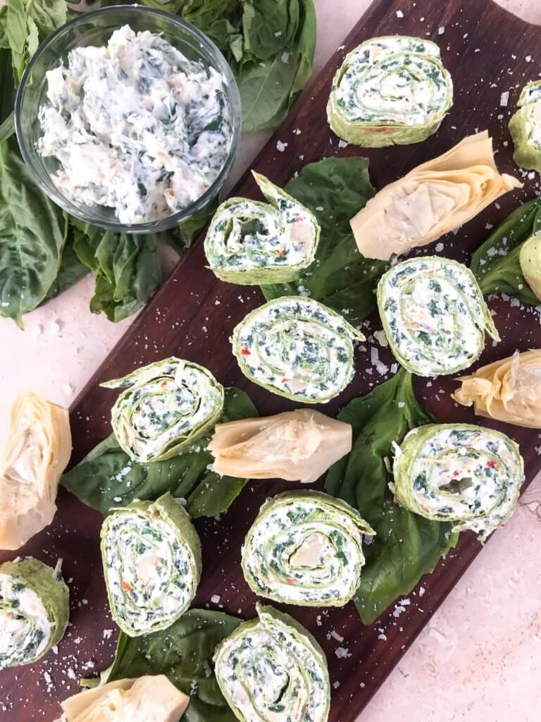 Slices of Spinach Artichoke Dip Pinwheels on a board