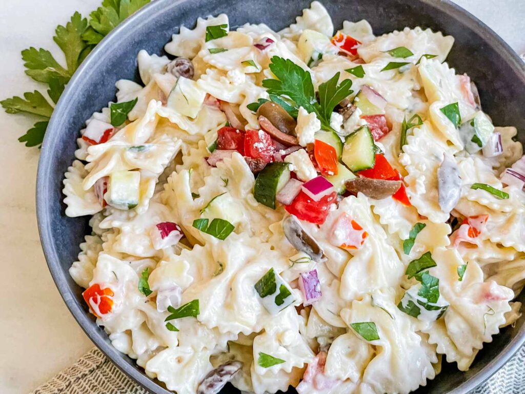 A gray bowl full of Creamy Greek Tzatziki Pasta Salad on a counter