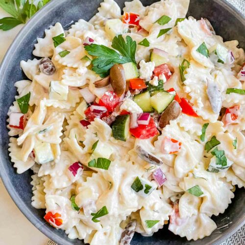 Top down view of Mediterranean Creamy Greek Tzatziki Pasta Salad in a gray bowl on a white counter