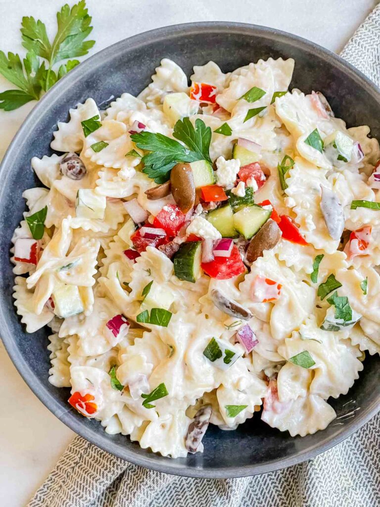 Top down view of Mediterranean Creamy Greek Tzatziki Pasta Salad in a gray bowl on a white counter