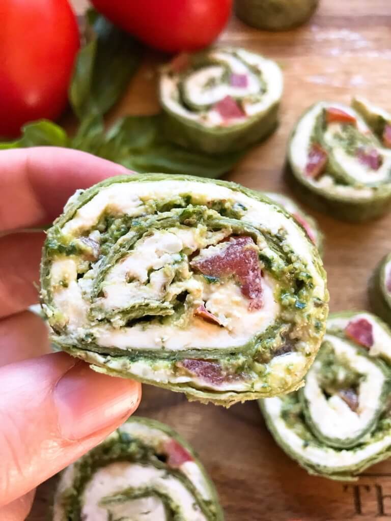 Fast and simple party appetizer recipe. Vegetarian Caprese Pesto Pinwheels Roll Ups are made of cream cheese, mozzarella, Parmesan, basil pesto, and tomatoes rolled in a flour tortilla. Easy finger food for entertaining or game day. #basilpesto #caprese #pinwheels #appetizers 