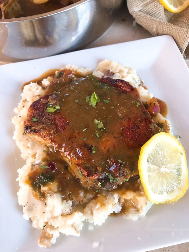 A quick and simple pork dinner recipe ready in 30 minutes. Skillet Pork Chops in Mustard Apple Cider Sauce featuring fall flavors is a one pot dish with lots of flavor. Gluten free meal. #porkchops #30minutemeals #onepotdinner