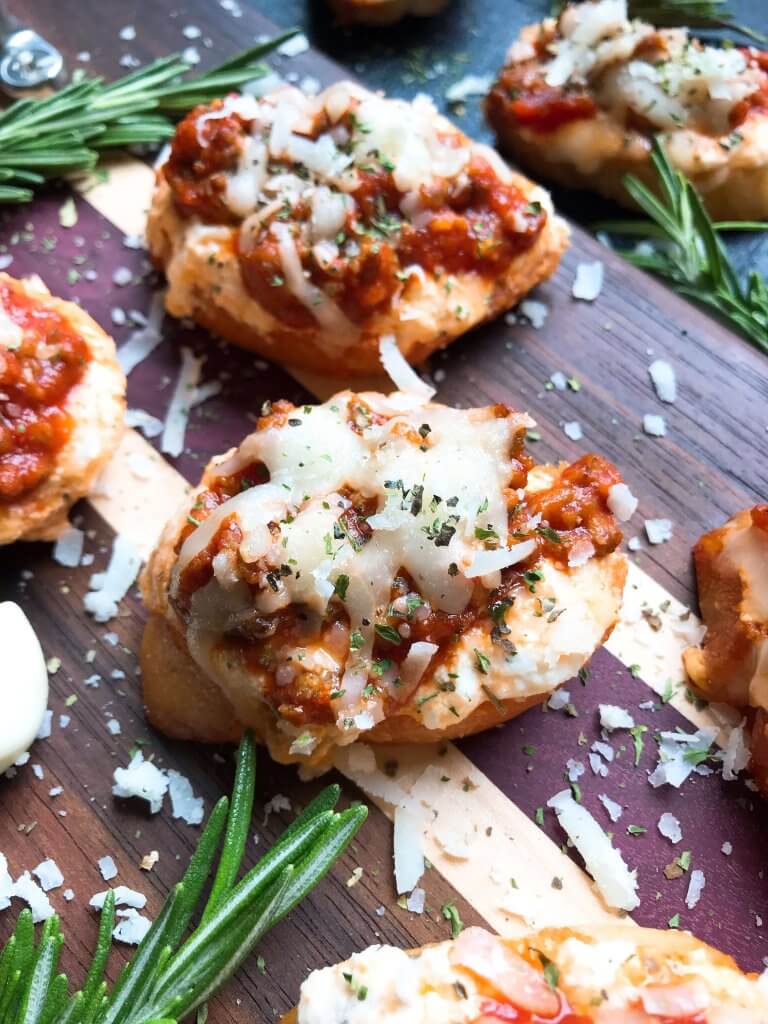 Quick and simple Simple Beef Lasagna Crostini are ready in less than 30 minutes. Ground beef is mixed in marinara and layered with three cheeses on bite sized appetizer toasts. Ricotta, mozzarella, and Parmesan cheeses make this a great entertaining or party food for game day and holidays. #lasagna #beefappetizer #partyfood