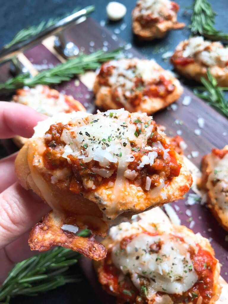 Quick and simple Simple Beef Lasagna Crostini are ready in less than 30 minutes. Ground beef is mixed in marinara and layered with three cheeses on bite sized appetizer toasts. Ricotta, mozzarella, and Parmesan cheeses make this a great entertaining or party food for game day and holidays. #lasagna #beefappetizer #partyfood