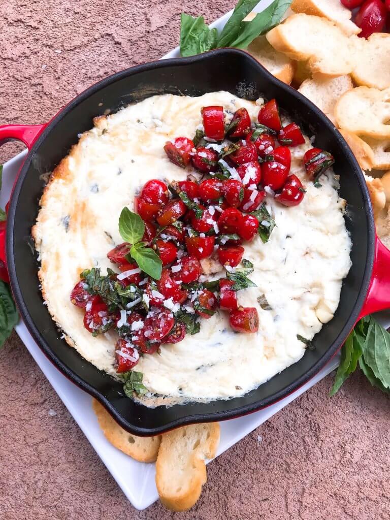 Caprese Cheese Dip is a fast and simple vegetarian Italian appetizer recipe. Three cheeses (mozzarella, cream cheese, Parmesan) are melted with seasonings and topped with fresh tomatoes, fresh basil, and balsamic vinegar. #cheesedip #caprese #italianrecipe