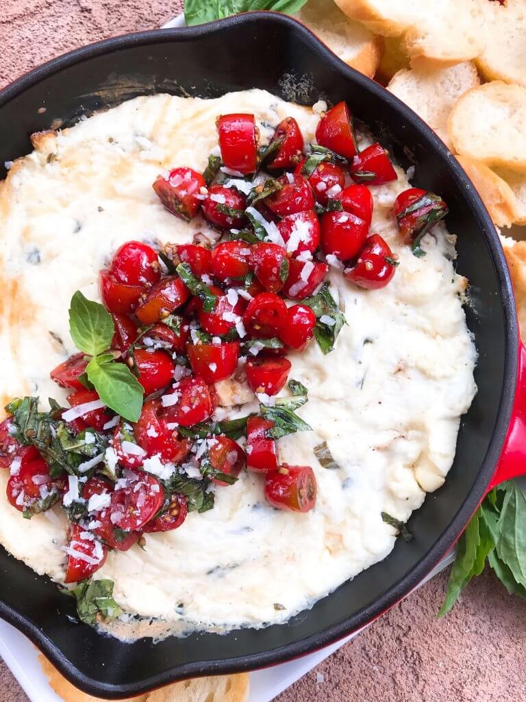 Caprese Cheese Dip is a fast and simple vegetarian Italian appetizer recipe. Three cheeses (mozzarella, cream cheese, Parmesan) are melted with seasonings and topped with fresh tomatoes, fresh basil, and balsamic vinegar. #cheesedip #caprese #italianrecipe