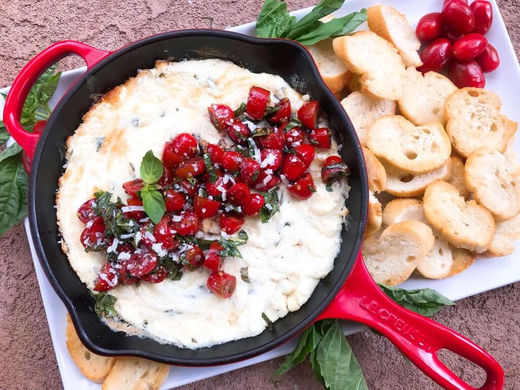 Caprese Cheese Dip is a fast and simple vegetarian Italian appetizer recipe. Three cheeses (mozzarella, cream cheese, Parmesan) are melted with seasonings and topped with fresh tomatoes, fresh basil, and balsamic vinegar. #cheesedip #caprese #italianrecipe