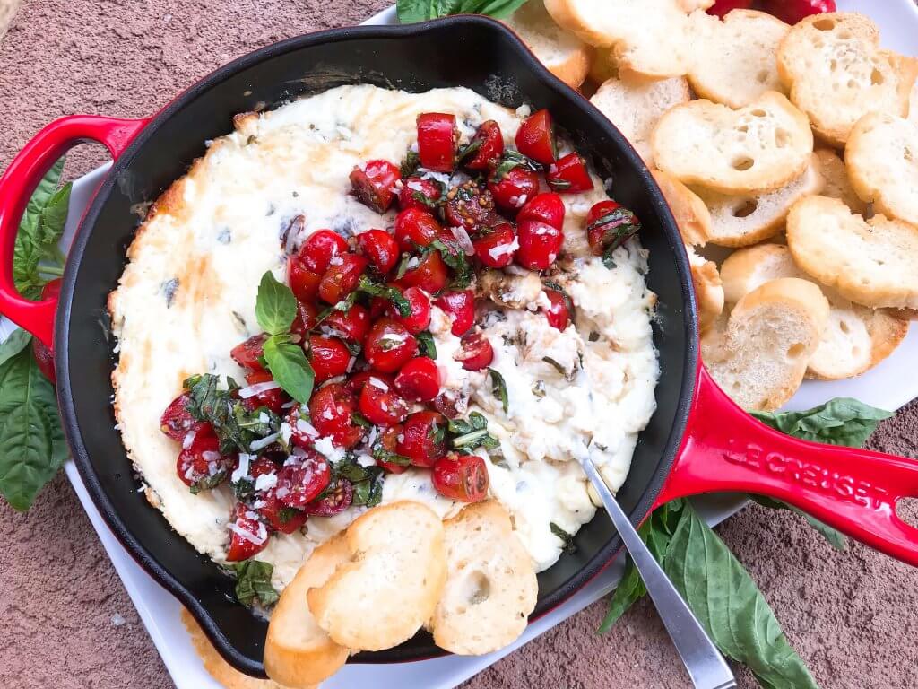 Caprese Cheese Dip is a fast and simple vegetarian Italian appetizer recipe. Three cheeses (mozzarella, cream cheese, Parmesan) are melted with seasonings and topped with fresh tomatoes, fresh basil, and balsamic vinegar. #cheesedip #caprese #italianrecipe
