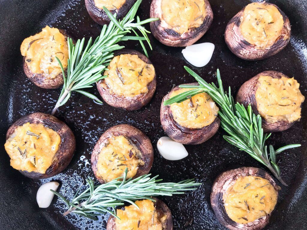 These Garlic Rosemary Polenta Stuffed Mushrooms are a simple and easy appetizer for a party or entertaining. A vegan, vegetarian, gluten free, and dairy free recipe. Leftover cornmeal polenta is a perfect filler. #stuffedmushrooms #partyappetizer #polenta