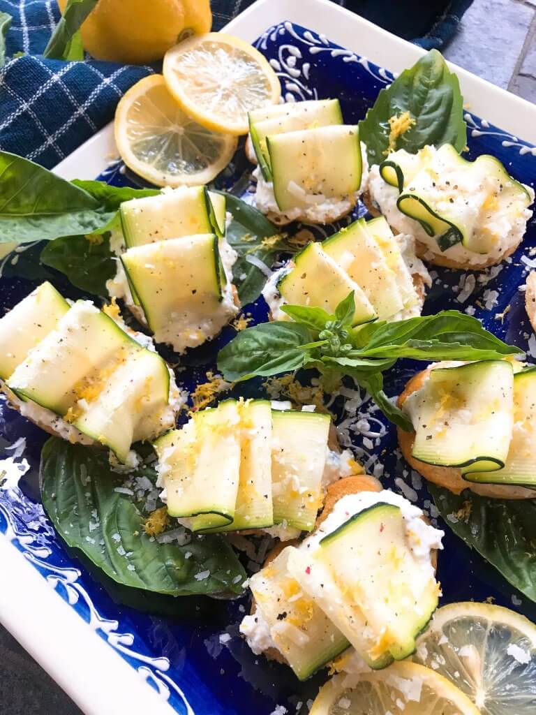 A close up of Zucchini Lemon Ricotta Crostini on a blue and white plate