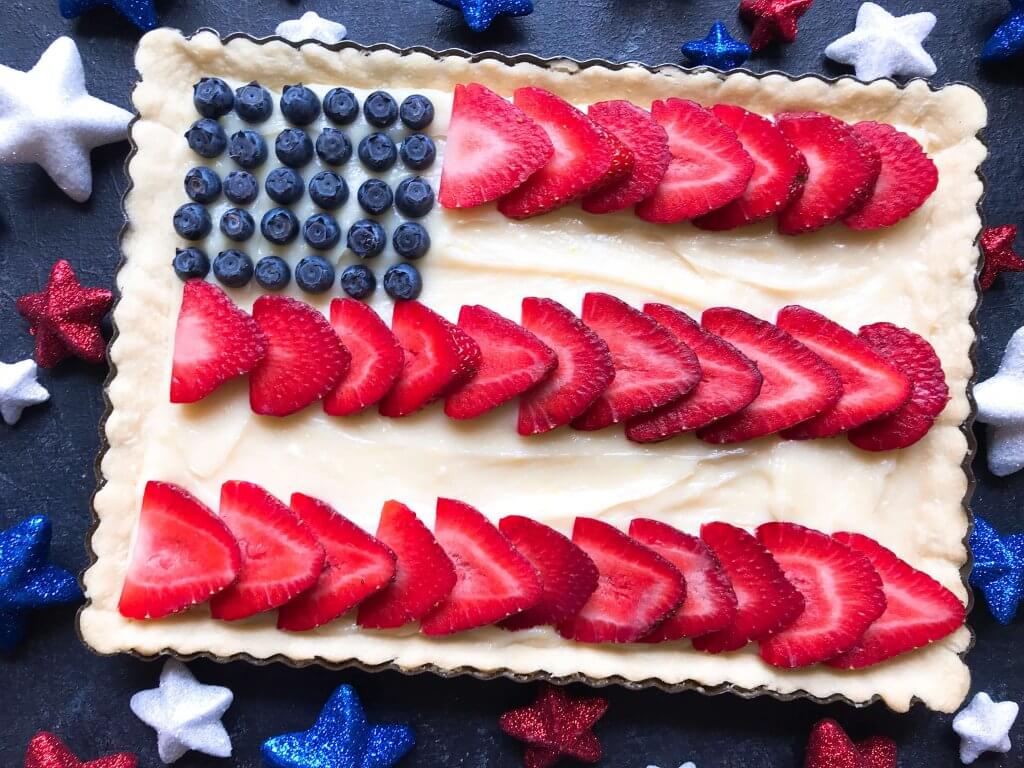 A quick and simple red, white, and blue dessert ready in 30 minutes. Patriotic American Flag Fruit Tart is a lemon cream cheese tart with fresh strawberries and blueberries. Great recipe for Labor Day, Memorial Day, and 4th of July BBQ or cookout. #americanrecipes #redwhitebluerecipes #redwhitebluedessert #fruittart