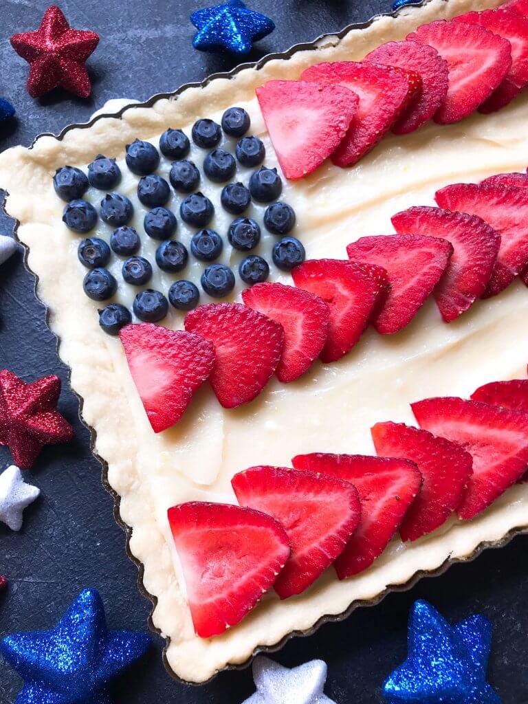 A quick and simple red, white, and blue dessert ready in 30 minutes. Patriotic American Flag Fruit Tart is a lemon cream cheese tart with fresh strawberries and blueberries. Great recipe for Labor Day, Memorial Day, and 4th of July BBQ or cookout. #americanrecipes #redwhitebluerecipes #redwhitebluedessert #fruittart