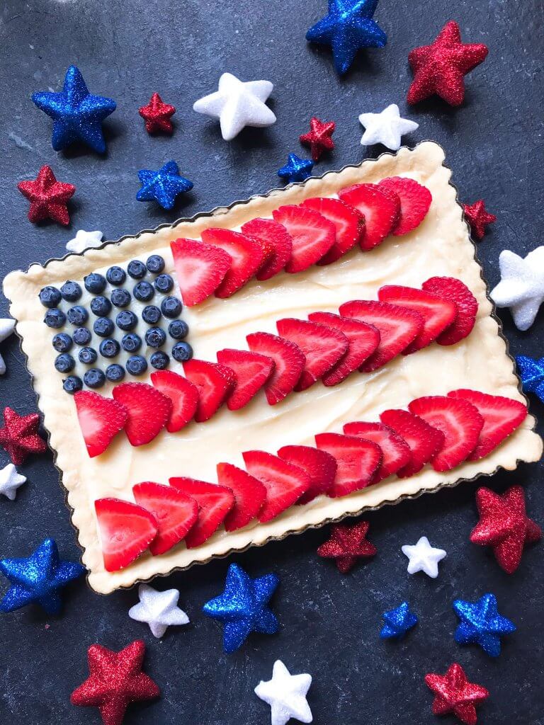 A quick and simple red, white, and blue dessert ready in 30 minutes. Patriotic American Flag Fruit Tart is a lemon cream cheese tart with fresh strawberries and blueberries. Great recipe for Labor Day, Memorial Day, and 4th of July BBQ or cookout. #americanrecipes #redwhitebluerecipes #redwhitebluedessert #fruittart