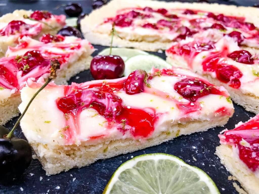 This fast and easy Cherry Limeade Tart is a perfect summer dessert recipe. A soft lime crust is filled with lime cream cheese filling and cherry pie swirls. #cherrylimeade #summerdessert #cherrydessert #tart